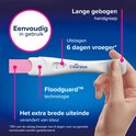 Hand houdt Clearblue zwangerschapstest met een brede grip en brede uiteinde. Twee blauwe lijnen zichtbaar. Tekst: "Eenvoudig in gebruik", "Uitslagen 6 dagen vroeger", "Floodguard™ technologie".
