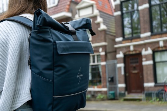 Donkerblauwe Voltano fietstas op een e-bike, gedragen door een persoon.
