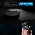 Zwarte robotstofzuiger op vloerkleed, met een hand die een afstandsbediening vasthoudt voor eenvoudige bediening.