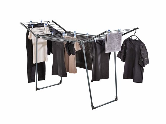 Étendoir noir avec divers vêtements, une serviette et des cintres.