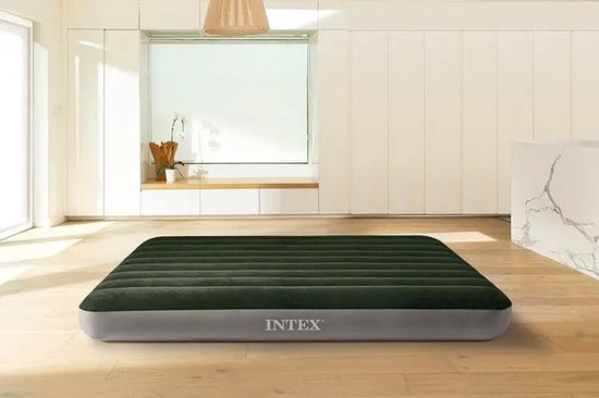 Donkergroen Intex luchtbed met grijze zijkanten in een lichte, moderne woonkamer.