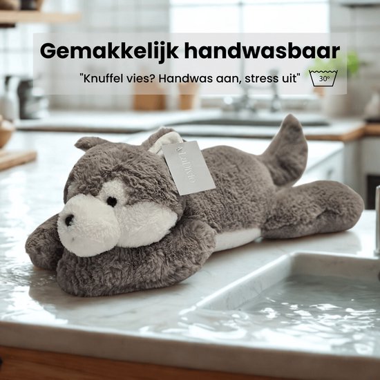 Grijze wolf knuffel op een marmeren aanrecht met water, 'Gemakkelijk handwasbaar' is in tekst erboven.