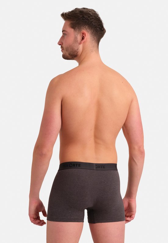 Man met kort bruin haar, draagt een donkergrijs gemêleerde shorty met donkere tailleband.