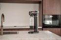 Zwarte bruiswatertoestel met doorzichtige fles in een moderne keuken.