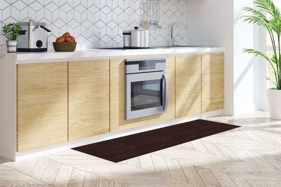 Tapis de cuisine brun foncé à motif bois de feuillus devant une cuisine blanche avec des armoires et des appareils en bois clair.