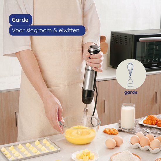 Handmixer van roestvrij staal en zwart die slagroom klopt in een kom.
