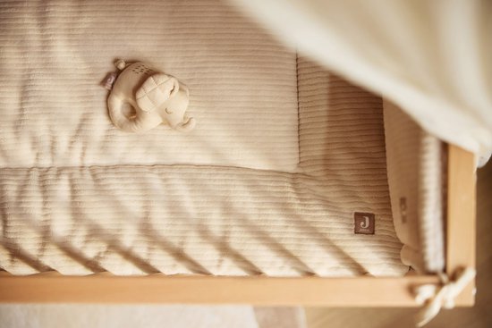 Crème corduroy wiegdeken met zachte textuur en een beige olifant rammelaar.