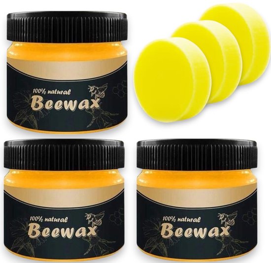Drie potjes bijenwas met zwarte deksels, naast drie ronde gele sponzen. Twee potjes zijn van voren gezien, één van opzij.