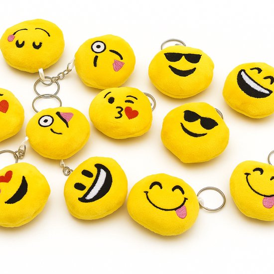Twaalf gele pluche emoji sleutelhangers met verschillende gezichtsuitdrukkingen, zoals een lachende smiley met zonnebril en een verlegen smiley met rode hartjes.