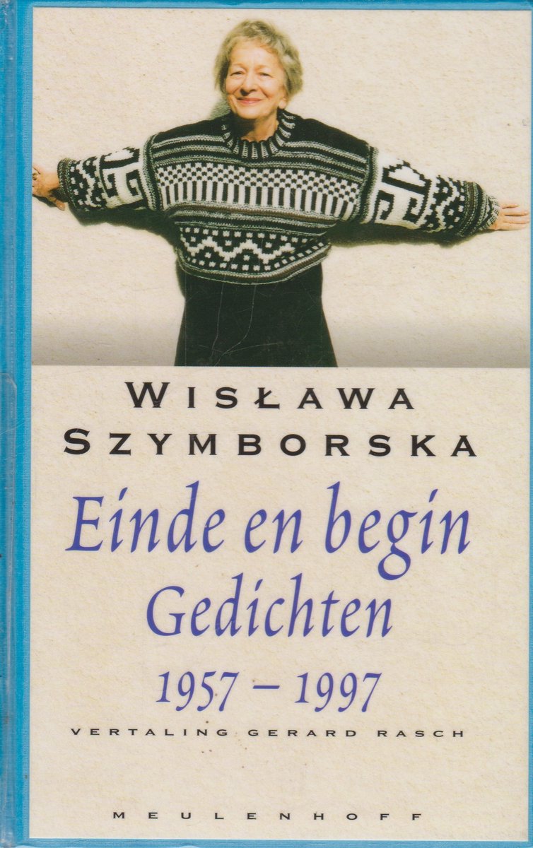 Een vrouw draagt een gebreide trui met geometrische patronen en geblokte mouwen.