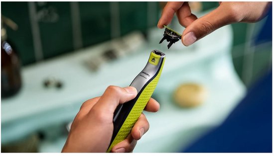 Een hand met een Philips OneBlade scheerapparaat, terwijl een ander hand een 360 mesje erop klikt.