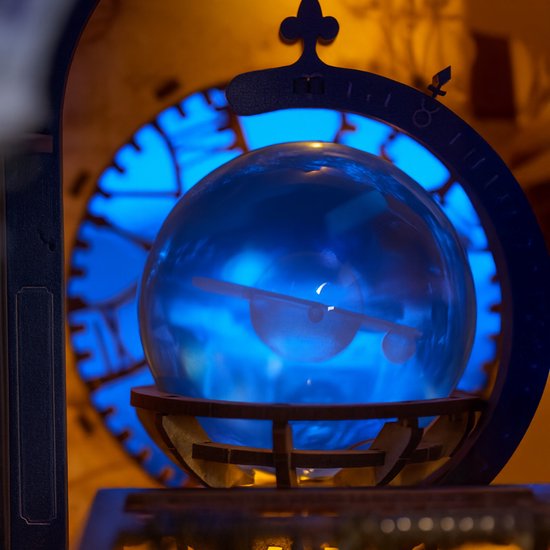 Blauwe, transparante wereldbol met een gouden wijzer, geplaatst in een houten standaard met blauwe verlichting.