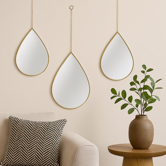 Drie druppelvormige spiegels met gouden frame, hangend aan een muur, naast een bank en vaas.