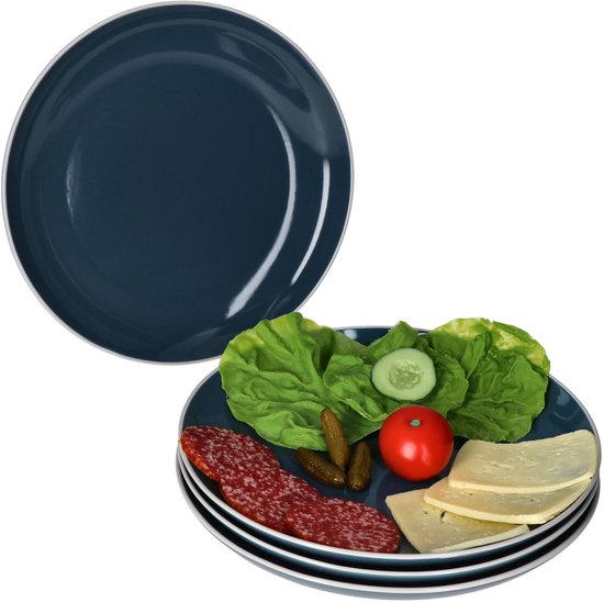 Een gestapeld set van vier diepe, donkerblauwe borden. Eén bord is gevuld met plakjes salami, kaas, augurkjes, sla, een halve komkommer en een tomaat.