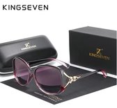 Paarse vlinderzonnebril met lichtroze pootjes en gouden details, inclusief zwart etui en doos met KINGSEVEN logo.