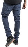 De achterkant van een man in een donkerblauwe jeans, met zwarte hoge Vans schoenen.