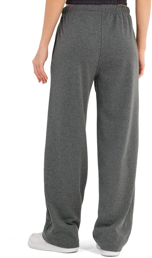 Achterkant van een model met blonde haren, draagt een wijde, antracietkleurige joggingbroek met koordje.