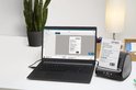 Zakelijke hand pakt een geprint label van de DYMO LabelWriter 5XL.
