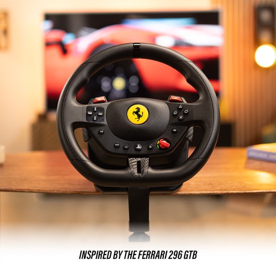 Zwart race stuur met Ferrari logo, op een bureau met een tv op de achtergrond die een rode auto toont. Tekst: INSPIRED BY THE FERRARI 296 GTB.