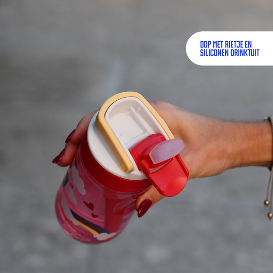 Hand houdt een rode drinkfles met vogels en regenboog vast. De dop met rietje en siliconen drinktuit is zichtbaar.