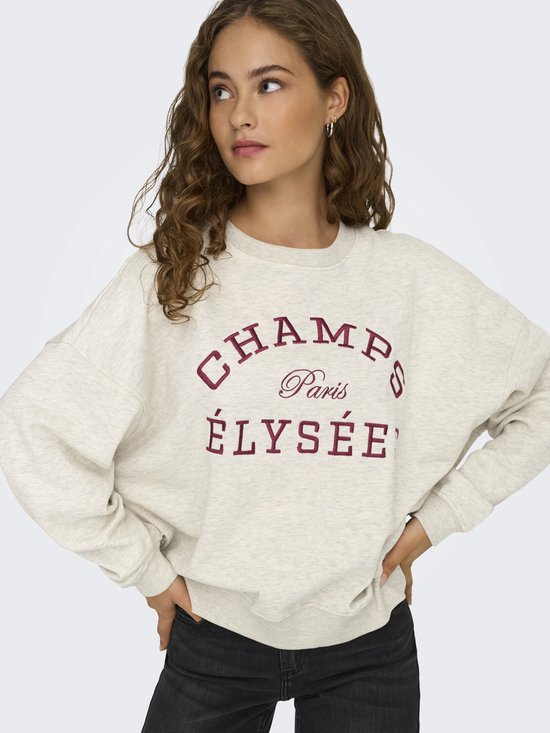 Lichtgrijze sweater met geborduurde tekst 'CHAMPS Paris ÉLYSÉES' in donkerrood, gedragen door een model.