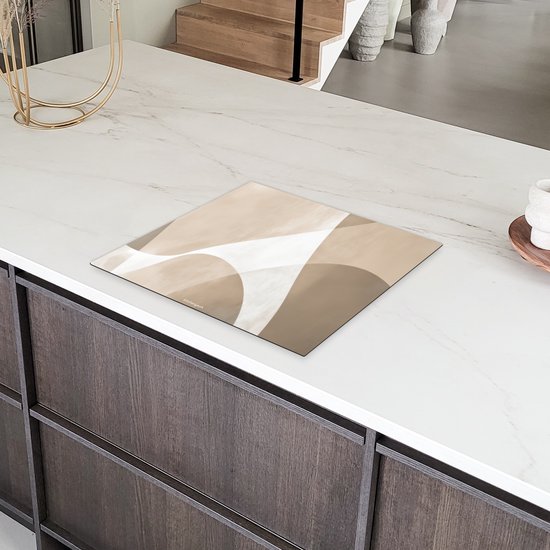 Abstracte beige beschermhoes voor inductiekookplaat op een wit marmeren aanrecht.
