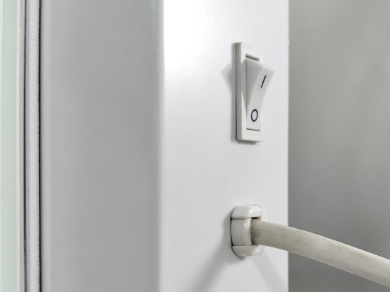 Witte schakelaar met "I/0" aanduiding en witte kabel ingang.