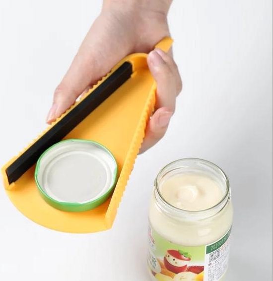 Gele potopener met een groene dop op een pot met crème.