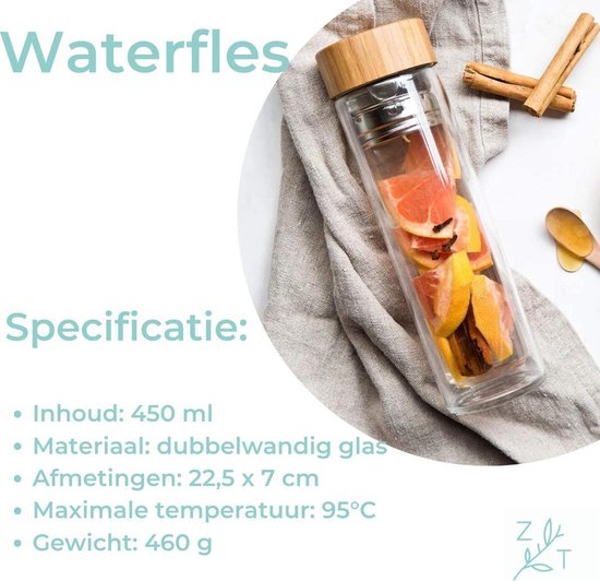 Dubbelwandige waterfles van glas met bamboe deksel gevuld met grapefruit en kruiden op een linnen doek.