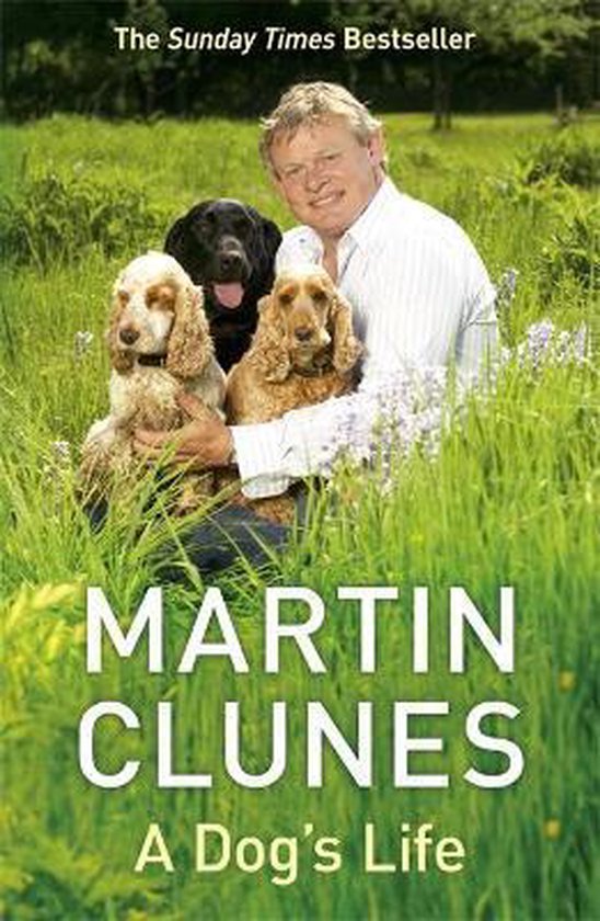 Martin Clunes met drie honden in het gras. Titel: A Dog's Life.