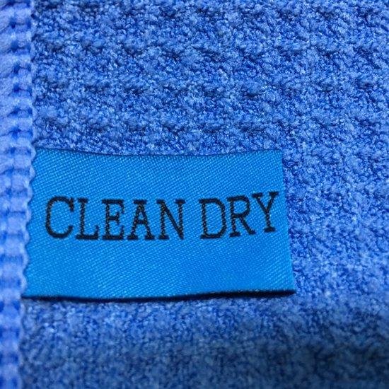 Blauwe "CLEAN DRY" label op een blauwe wafeldoek.
