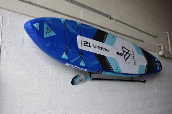 Planche de paddle bleue et blanche "Marlin 12" avec pagaie fixée au mur.