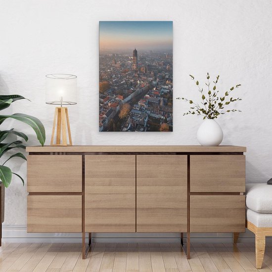 Une peinture de la skyline d'Utrecht au lever du soleil, avec la tour Domtoren au centre. La ville est enveloppée de brume.