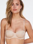 Model draagt een beige balconette bh met kanten details op de cups. Verstelbare bandjes.