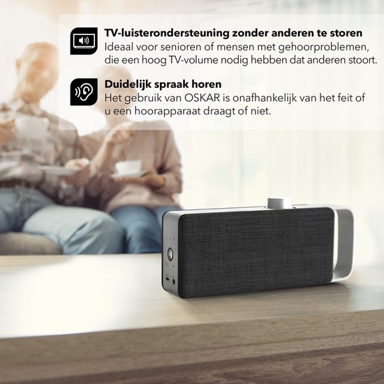 Zwarte luidspreker met zilverkleurige handgreep, naast twee mensen op een bank. Tekst: "TV-luisterondersteuning zonder anderen te storen" en "Duidelijk spraak horen".