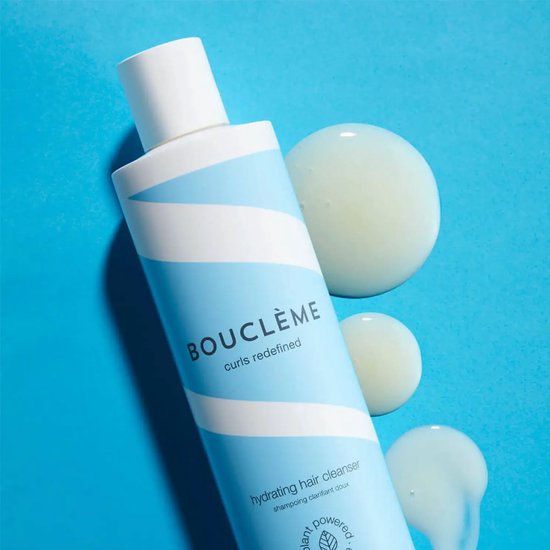 Lichtblauwe fles met witte golvende strepen. Drie druppels product liggen ernaast op een blauwe achtergrond.