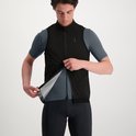 Man trekt zwart fietsjack open, met grijs shirt en zwarte fietsbroek.