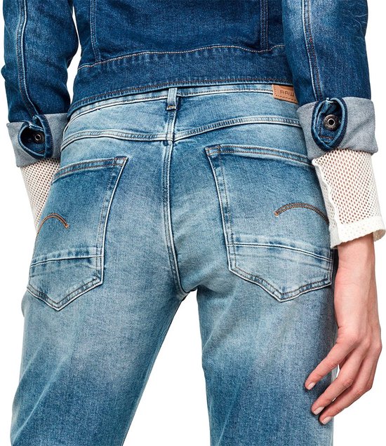Close-up van de achterkant van een vrouw in een lichte, gescheurde jeans met G-Star logo.