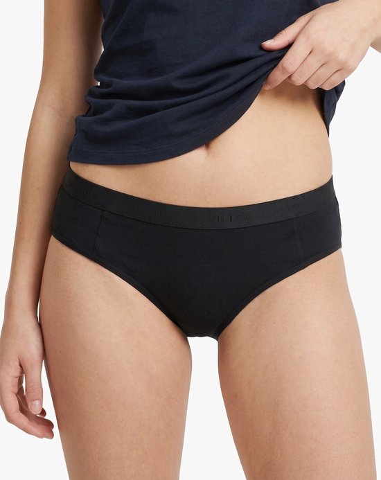 Model draagt een zwarte ten Cate slip met bijpassende elastische tailleband.