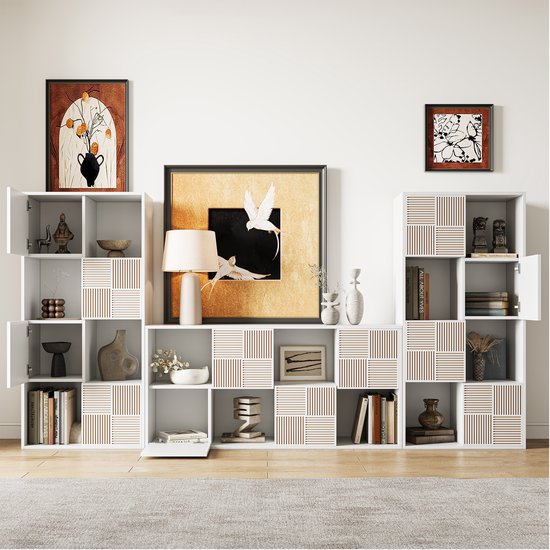 Opstelling van witte kasten met boeken, decoraties en kunst. Sommige vakken hebben een patroon van verticale ribbels.