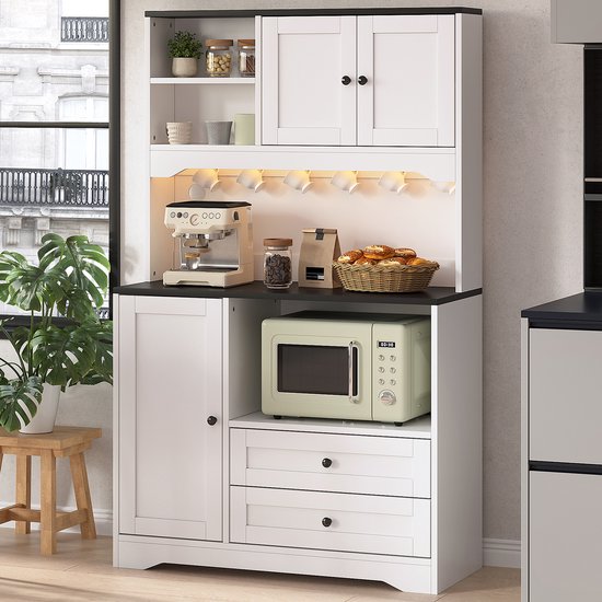 Meuble de cuisine blanc avec poignées noires, micro-ondes, machine à café et espace de rangement.