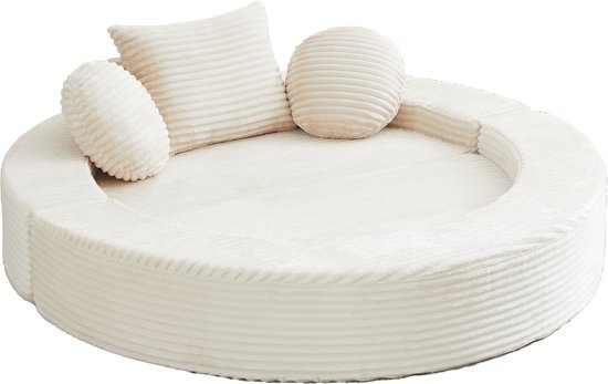 Rond beige ribfluwelen dagbed met drie kussens.
