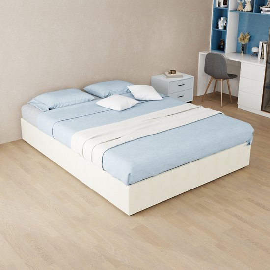 Beige gestoffeerd bed in een slaapkamerinterieur met blauw beddengoed en witte accenten.