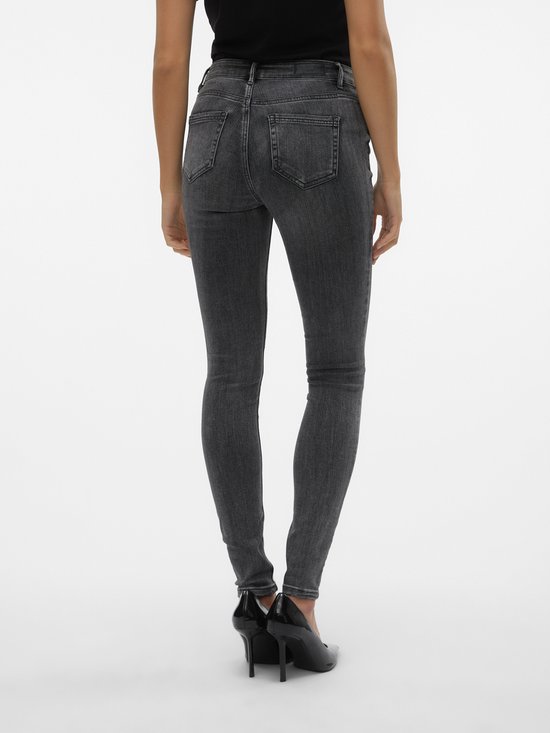 Achterkant van een vrouw met grijze skinny jeans.