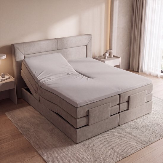 Drap-housse split pour surmatelas en jersey de coton gris clair sur un lit double réglable dans une chambre moderne.