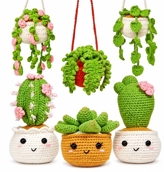 Zes gehaakte planten in potjes. Twee hangende planten met roze bloemen, één hangende plant, twee cactussen en één succulente plant. Allemaal met gezichtjes.