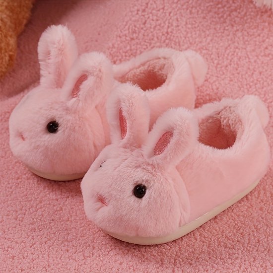 Een paar roze konijnenpantoffels van zacht pluche op een roze ondergrond.