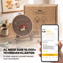 Borduurpakket van Nolad naast een telefoon met 4,8 sterren beoordeling. Een borduurring staat op een houten standaard.