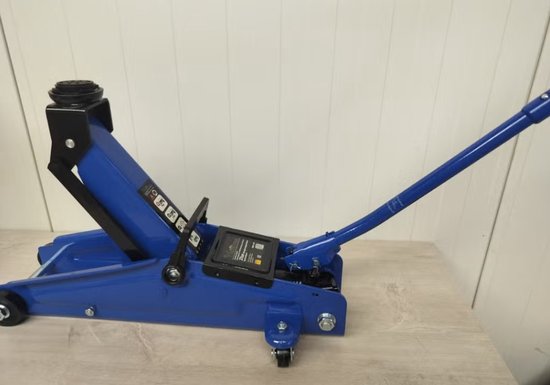 Blauwe 3-tons hydraulische krik in opstaande positie met handgreep op een houten tafel.