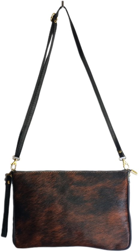 Bruine en zwarte koeienhuid clutch met zwarte leren schouderband en gouden hardware.